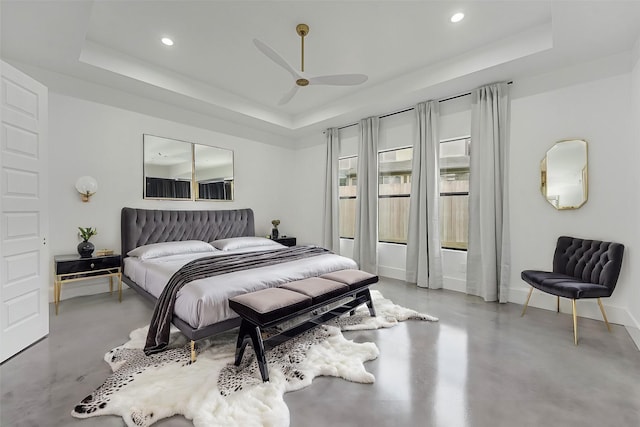 bedroom with ceiling fan and a raised ceiling