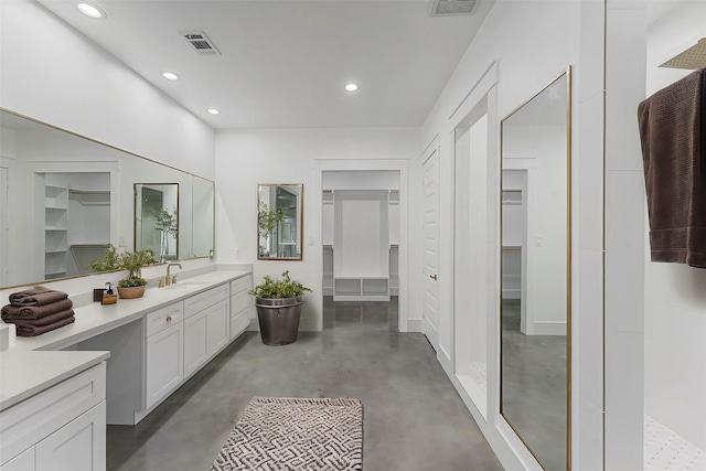 bathroom featuring a shower, vanity, and concrete flooring