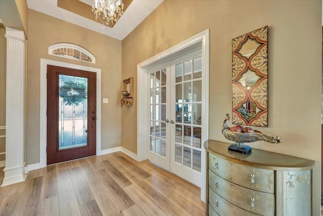 foyer featuring a notable chandelier, light hardwood / wood-style flooring, and french doors