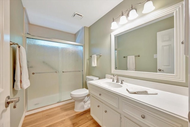 bathroom featuring vanity, hardwood / wood-style flooring, toilet, and walk in shower