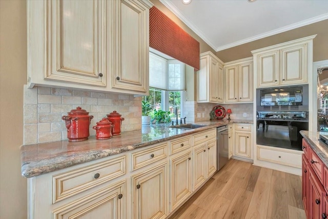 kitchen featuring tasteful backsplash, cream cabinets, black appliances, and sink