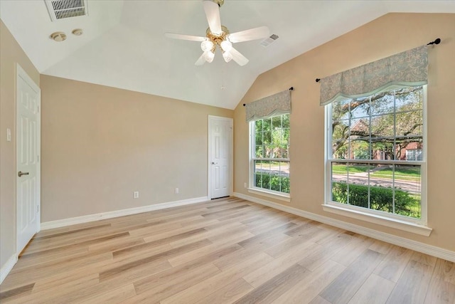 spare room with ceiling fan, vaulted ceiling, and light wood-type flooring