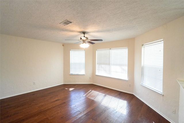 empty room featuring dark hardwood / wood-style flooring, plenty of natural light, and ceiling fan