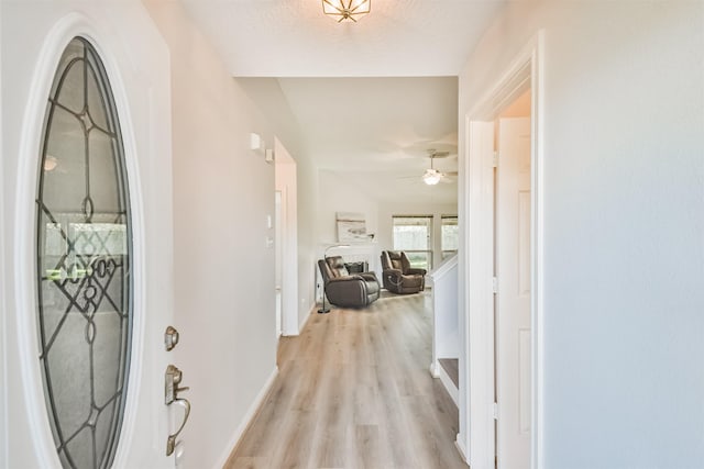 foyer entrance featuring ceiling fan, light hardwood / wood-style floors, and a textured ceiling