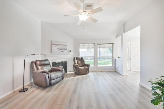 sitting room featuring a fireplace, light hardwood / wood-style flooring, ceiling fan, and lofted ceiling