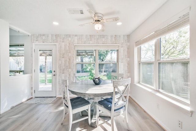 dining space with light hardwood / wood-style flooring and ceiling fan