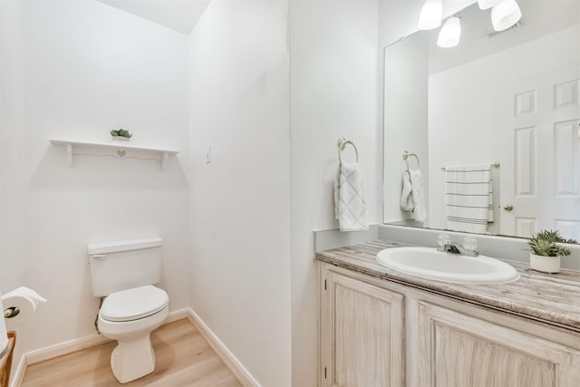 bathroom with hardwood / wood-style floors, vanity, and toilet