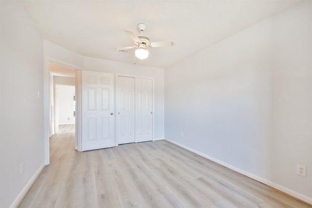 unfurnished bedroom with ceiling fan, light wood-type flooring, and a closet