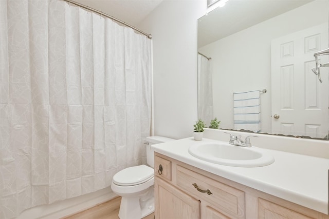 full bathroom featuring hardwood / wood-style floors, vanity, shower / tub combo, and toilet