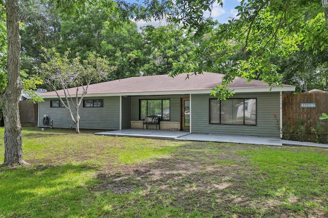 rear view of house featuring a lawn, a patio area, and fence