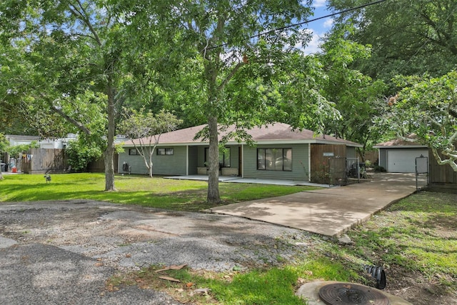 ranch-style house with a front yard, fence, and an outbuilding