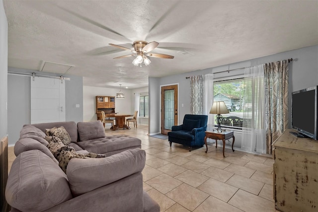 living area with visible vents, ceiling fan, a textured ceiling, and light tile patterned flooring