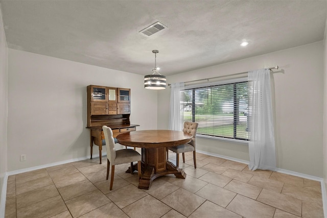 dining room with light tile patterned floors, visible vents, and baseboards