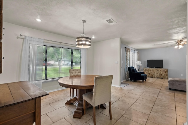 dining space with light tile patterned floors, ceiling fan, visible vents, and baseboards