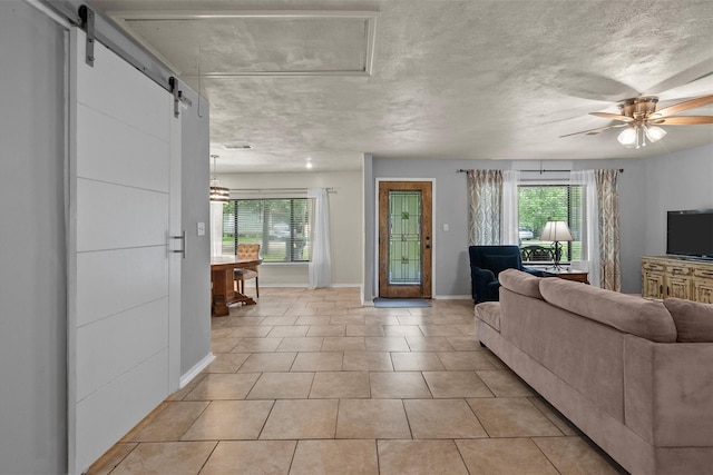 living area with a wealth of natural light, a textured ceiling, and a barn door