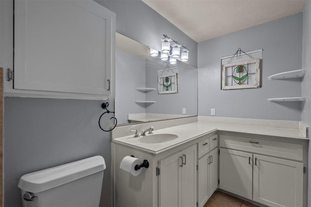 bathroom featuring tile patterned flooring, vanity, and toilet