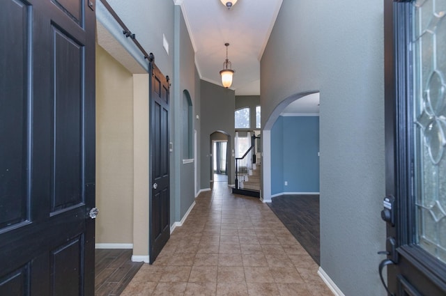 entrance foyer featuring a barn door, a high ceiling, and ornamental molding