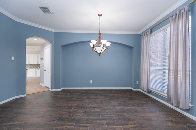 spare room with crown molding and a notable chandelier