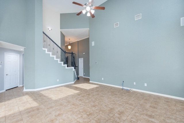 unfurnished living room with ceiling fan and a high ceiling