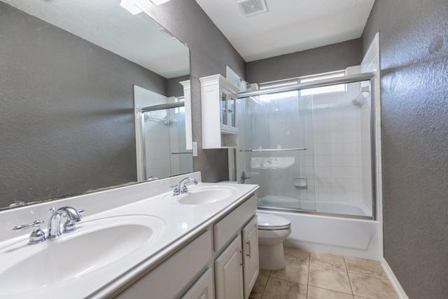 full bathroom with tile patterned flooring, vanity, enclosed tub / shower combo, and toilet