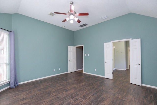 unfurnished bedroom featuring multiple windows, ceiling fan, dark wood-type flooring, and vaulted ceiling