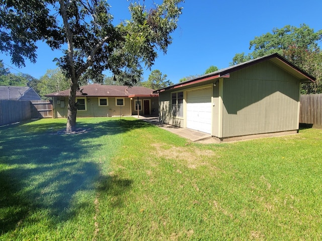 rear view of property with a lawn and a garage