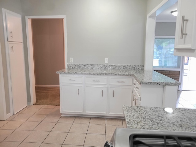 kitchen featuring kitchen peninsula, white cabinetry, light tile patterned floors, and light stone countertops