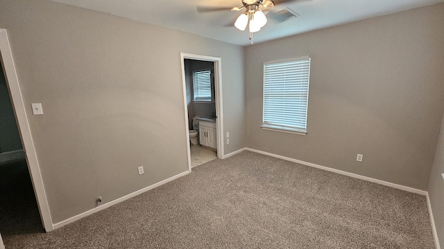 unfurnished bedroom with ceiling fan, light colored carpet, and ensuite bathroom