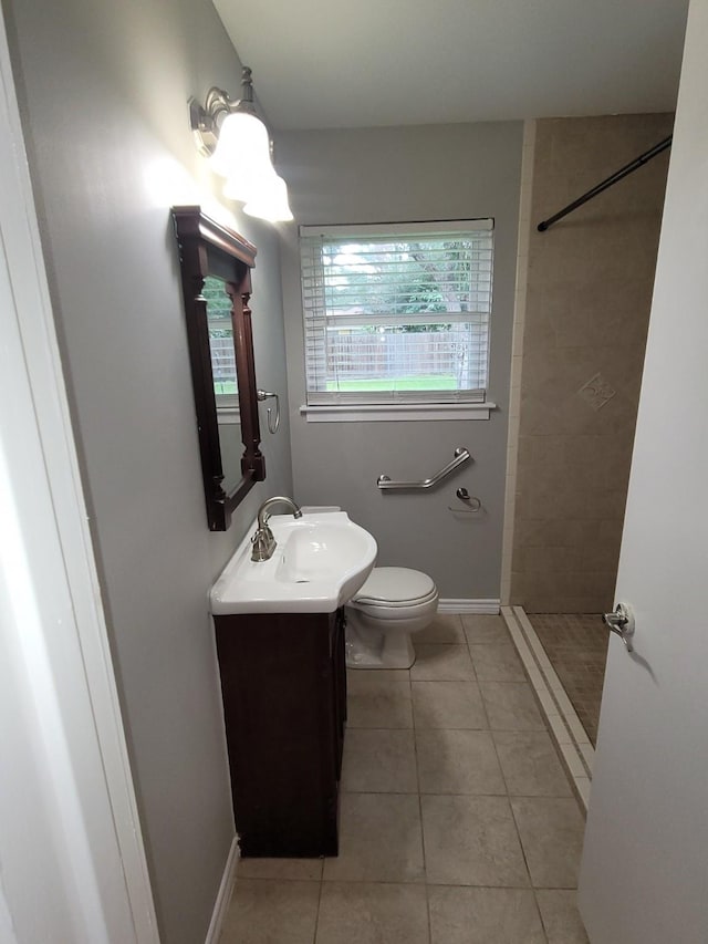 bathroom featuring tile patterned floors, vanity, toilet, and tiled shower