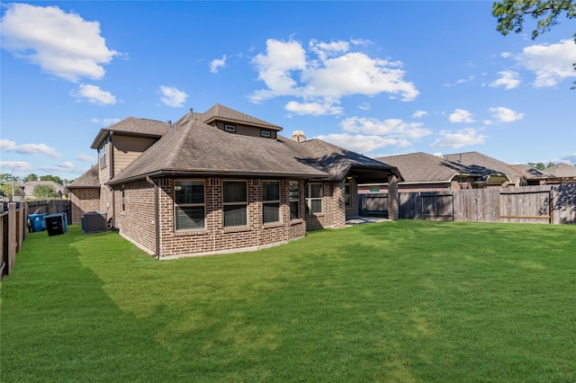 rear view of property with a lawn and central AC