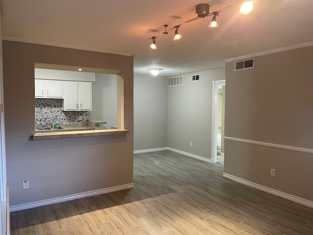 spare room featuring crown molding and hardwood / wood-style floors