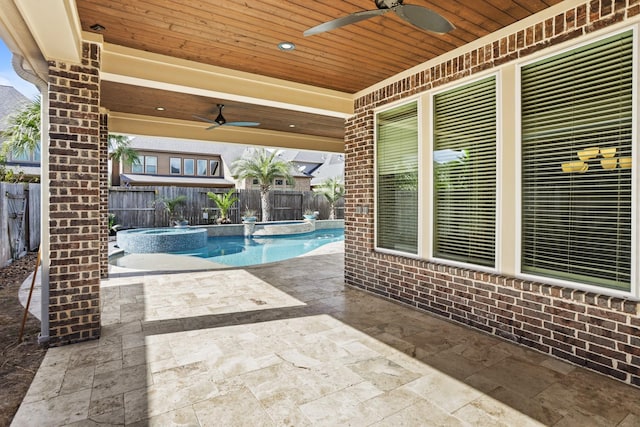 view of swimming pool with ceiling fan, a patio, and an in ground hot tub