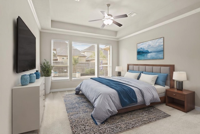 carpeted bedroom with a raised ceiling and ceiling fan