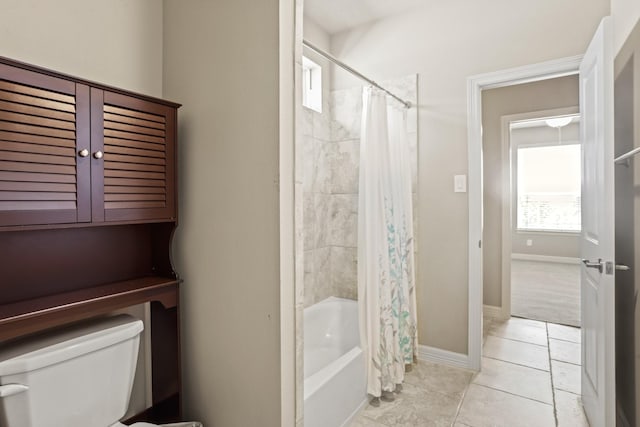 bathroom featuring tile patterned flooring, shower / bath combo with shower curtain, and toilet