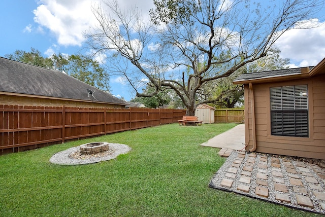 view of yard with a storage unit, a patio area, and an outdoor fire pit