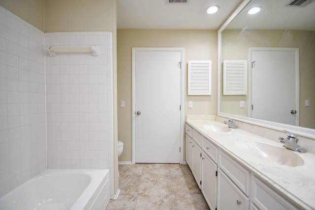 full bathroom with vanity, toilet, and tiled shower / bath