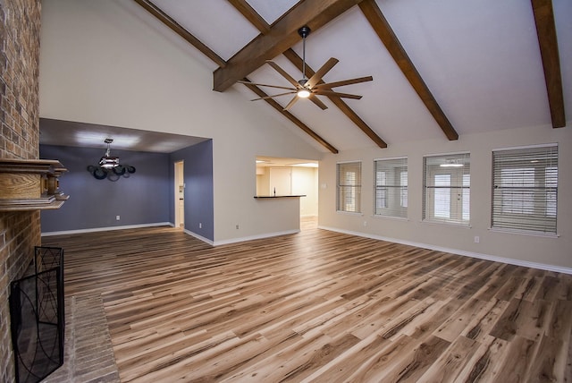 unfurnished living room featuring a brick fireplace, ceiling fan with notable chandelier, beam ceiling, hardwood / wood-style flooring, and high vaulted ceiling