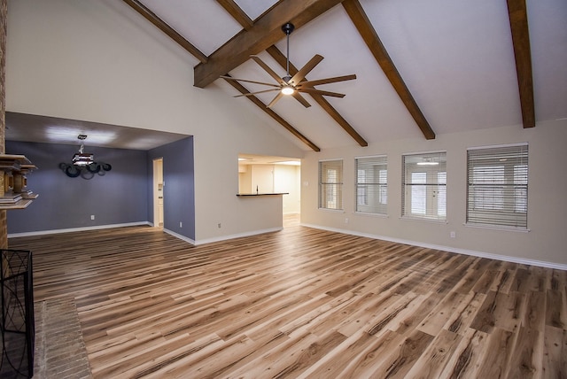 unfurnished living room featuring hardwood / wood-style flooring, ceiling fan with notable chandelier, beam ceiling, and high vaulted ceiling