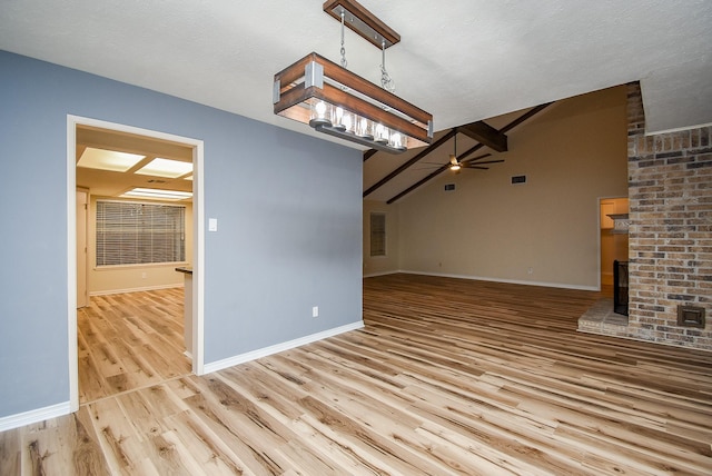 unfurnished living room with lofted ceiling with beams, light hardwood / wood-style flooring, and ceiling fan