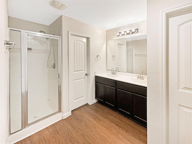 bathroom featuring vanity, an enclosed shower, and hardwood / wood-style flooring