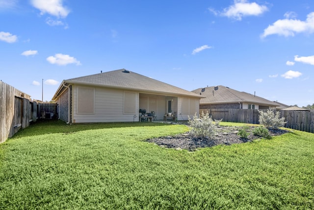 rear view of house featuring a lawn