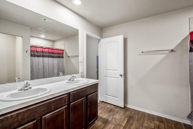 bathroom featuring hardwood / wood-style floors, vanity, and walk in shower