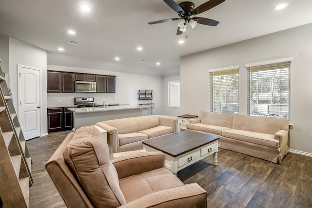 living room featuring ceiling fan and dark hardwood / wood-style flooring