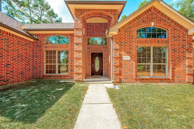 view of exterior entry featuring a yard