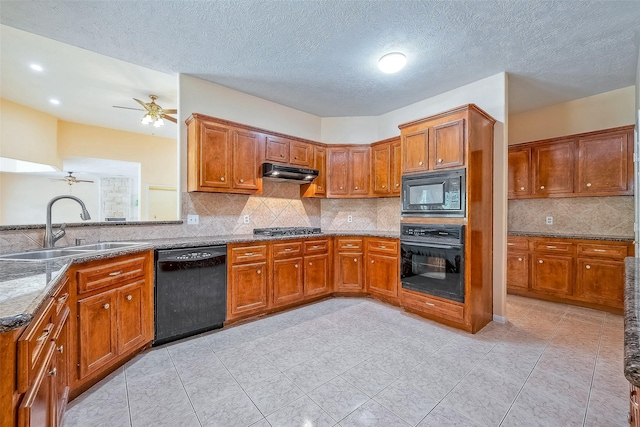 kitchen featuring sink, tasteful backsplash, dark stone counters, a textured ceiling, and black appliances