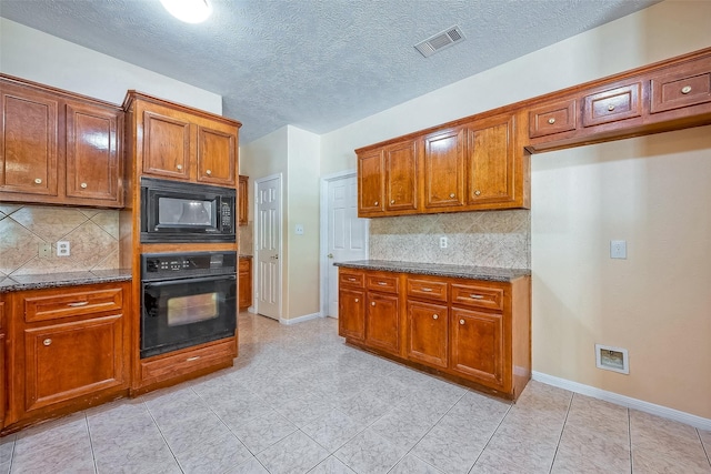 kitchen featuring black appliances, decorative backsplash, dark stone countertops, and a textured ceiling