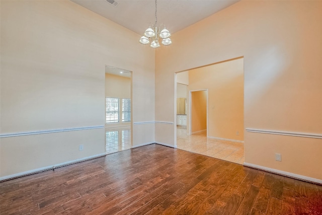 unfurnished room featuring vaulted ceiling, light wood-type flooring, and a chandelier