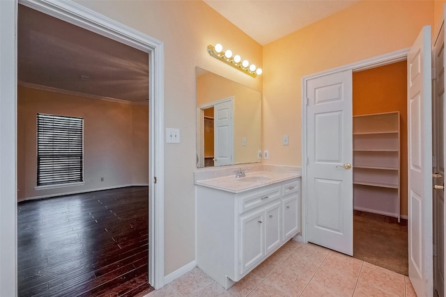 bathroom featuring tile patterned flooring, vanity, and ornamental molding