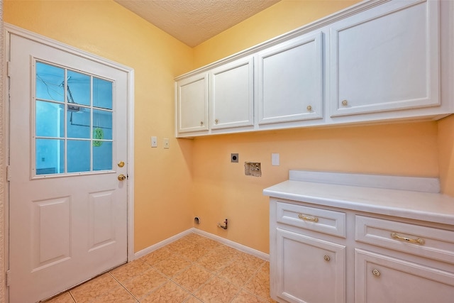 clothes washing area featuring electric dryer hookup, cabinets, hookup for a gas dryer, a textured ceiling, and light tile patterned flooring