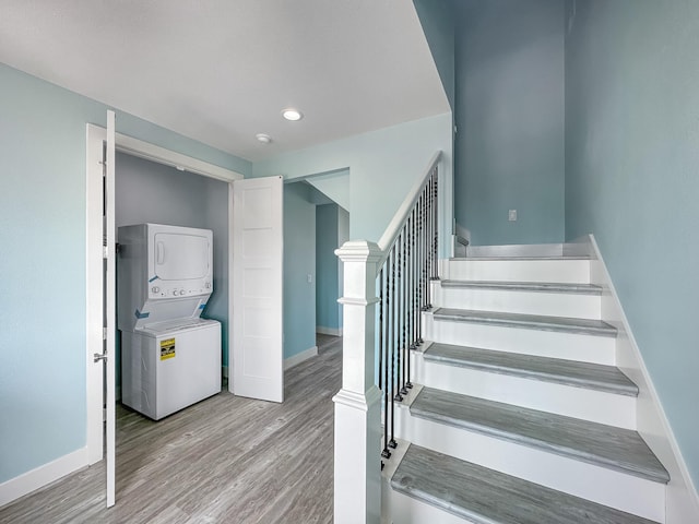 stairway featuring hardwood / wood-style flooring and stacked washer and clothes dryer